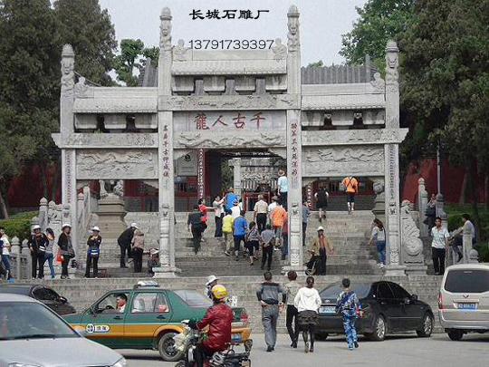 千古人龍石雕牌坊為四柱三間三樓式，上面雕刻著吉祥的圖案。